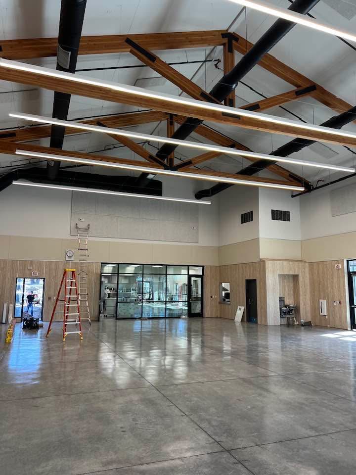 Finished commercial hall with exposed wood trusses and polished floor