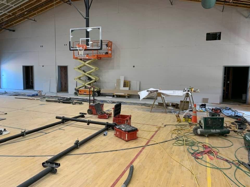 Auditorium under construction with basketball hoop and lift