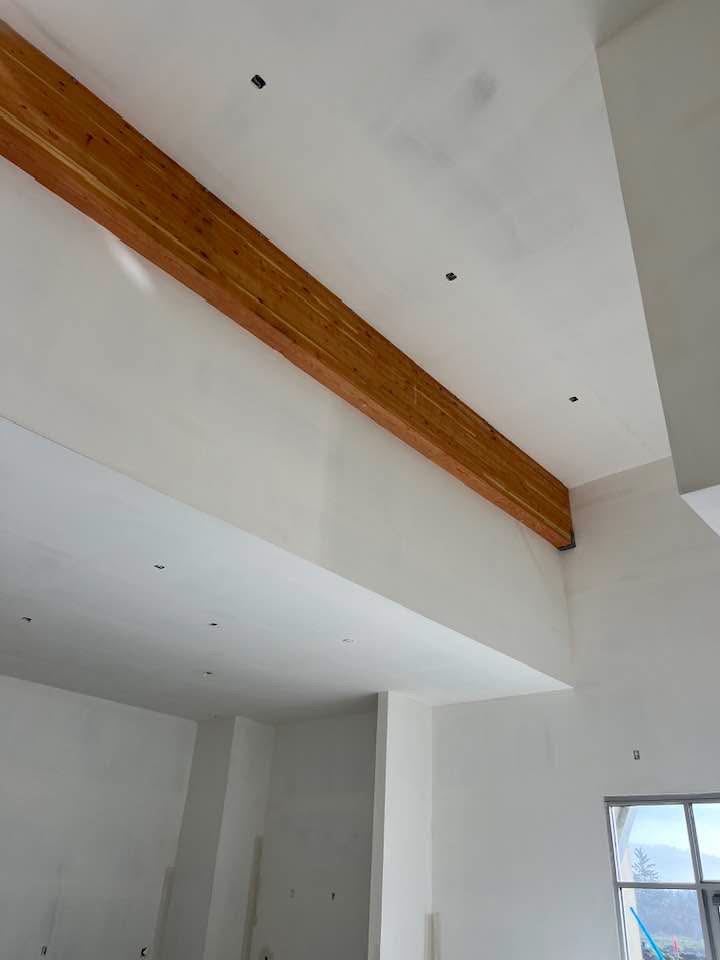 Smooth finished ceiling with exposed wood beam